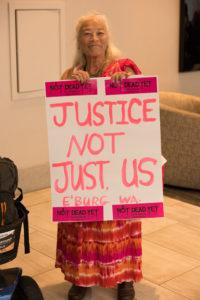 A NCIL Member carries a sign that reads "Justice Not Just Us"