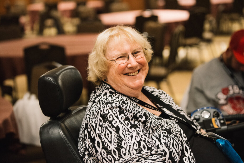 Mary Margaret Moore smiles brightly toward the camera at NCIL’s Annual Conference on Independent Living. 